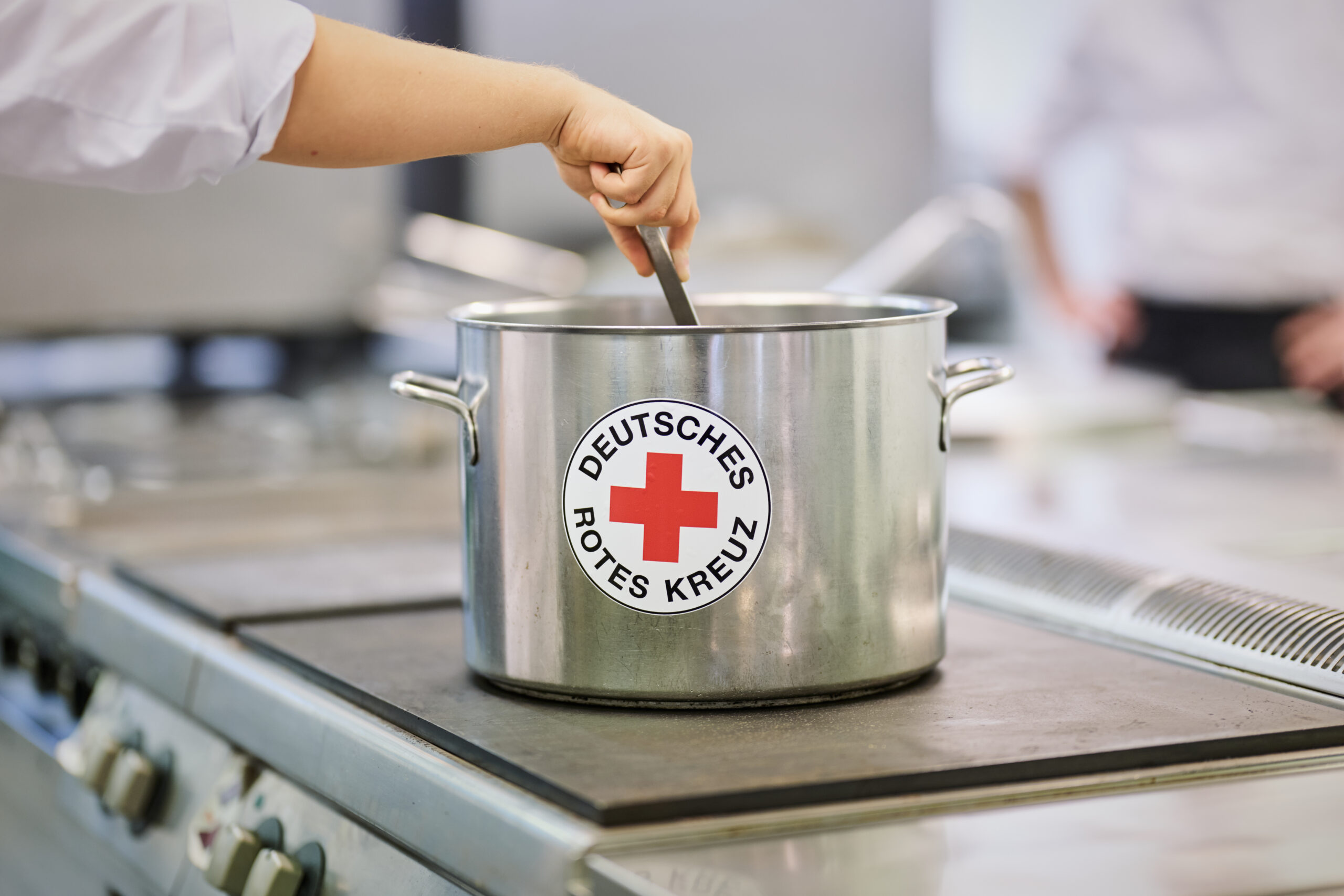 Topf mit DRK Logo auf dem Kochfeld einer Feldküche
- 2025